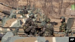 3月11日在朝鲜与韩国边境附近的村庄板门店,韩国士兵坐在自动推进的炮车上,他们正在进行军事演习以应对可能来自朝鲜的打击。