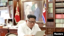 朝中社6月22日发布照片,显示金正恩正在仔细阅读特朗普的私人信函。
