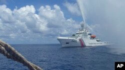 在斯卡伯勒浅滩(黄岩岛)附近,一艘中国海警船向一艘菲律宾渔船靠近。2015年9月23日)