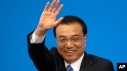 资料图片:2019年3月15日,在北京人民大会堂,全国人民代表大会闭幕后,时任国务院总理李克强在记者会上挥手致意。(美联社)