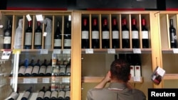 资料照:澳大利亚国库酒庄拥有的Penfolds葡萄酒酒庄店员将葡萄酒放到酒架上陈列。