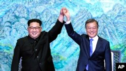 朝鲜领导人金正恩和韩国总统文在寅在板门店签署联合宣言后一起举手。(2018年4月27日)