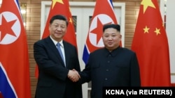 资料照片:朝鲜领导人金正恩在中国国家主席习近平访问平壤期间与其握手。(朝鲜中央通讯社2019年6月21日发布)