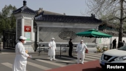 在2020年4月4日清明节期间,北京的医护人员在一个墓园外给驶入汽车驾驶员量体温。