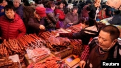 置办年货的北京市民在超市的腊肉腊肠摊位前选购。(2020年1月16日)