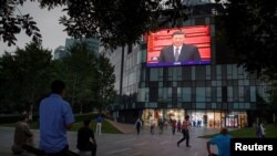 北京一家商场的电子屏幕上播放中国国家主席习近平出席全国政协年度会议开幕式。(2020年5月21日)