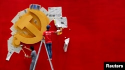 资料照:浙江省嘉兴南湖革命纪念馆的两名工人在墙上漆一面中共党旗。