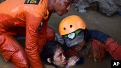 救援人员从一所被地震和海啸摧毁的房屋中解救一名15岁的印尼女孩。 (2018年9月30日)