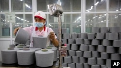 资料照片:在政府为外国记者组织的一次参观中,位于新疆阿克苏的华孚时尚一家工厂内的工人在包装棉线团。(2021年4月20日)