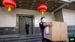 资料照片:一名联邦快递雇员从被美国下令关闭的中国驻休斯顿领事馆搬走一个纸箱。(2020年7月23日)