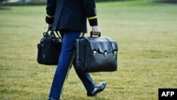 Працівник Білого дому несе ядерні коди до гелікоптера президента США на галявині Білого дому, Вашингтон, 20 січня 2021 року. Президент Дональд Трамп вилетів звідти, залишаючи Білий дім, перед інавгурацією Джо Байдена як президента.