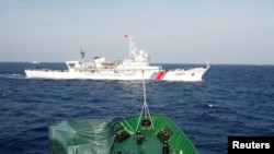资料照 - 在离越南海岸210公里的南中国海上,从一艘越南海岸警卫队的船上看附近的中国海警船。(2014年5月14日)