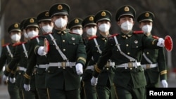戴着口罩的中国武警士兵走过北京街头。(资料照)
