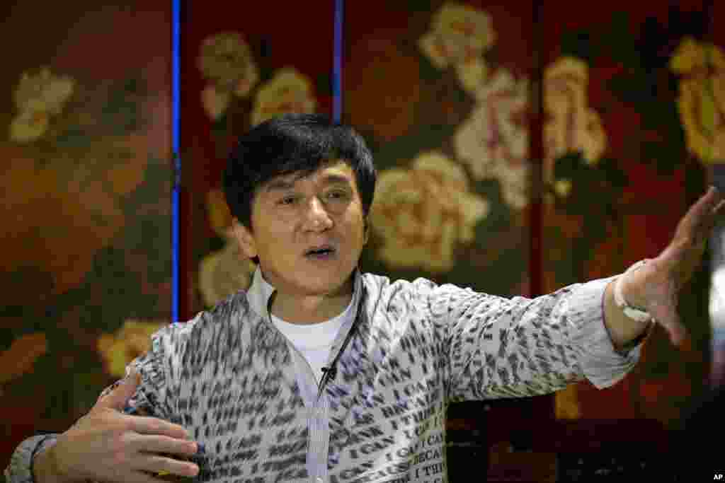 成龙在北京接受采访。他的上衣上印着的英文词语是“我能”“我认为我能”……(2015年8月3日)