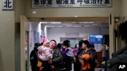 资料照片:家长和孩子在北京儿童医院的候诊室等候。(2016年12月18日)