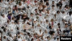2018年6月28日,美国华盛顿,移民活动人士游行到国会山之后,在哈特参议院办公楼内抗议示威,用白色毯子包裹自己,象征着在德克萨斯州美国 - 墨西哥边境拘留所用类似毯子包裹的移民儿童。