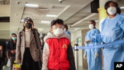 资料照片:一架中国南方航空公司班机的乘客抵达肯尼亚乔莫·肯雅塔国际机场后接受新型冠状病毒筛查。(2020年1月29日)