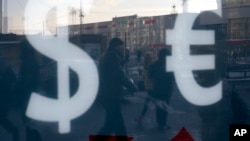 На Фото: Москва, люди проходять повз обмінник валют