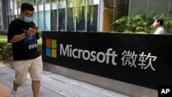 中国北京,一名男子路过微软办公室时看了看自己的智能手机(2020年8月7日)。