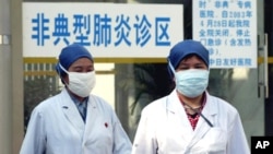 资料照:中国医务人员走过北京的一个非典肺炎诊区。(2003年4月29日)