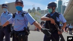 当香港首位被控涉嫌违反国安法的唐英杰坐着轮椅被押解至法院时港警戒备(2020年7月6日)