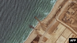 资料照片:这张卫星图像显示了2024年5月29日美国在加沙地带海岸建造的三叉戟码头的剩余部分,此前恶劣天气将其破坏。(法新社照片)
