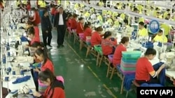 资料照:中国新疆和田一所职业教育训练中心的穆斯林学员在服装厂里工作。(2019年1月9日)