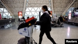 中国成都双流国际机场,旅客又带起了口罩。