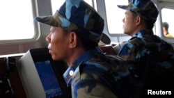 越南巡逻艇上的人员在南中国海有争议水域观察附近的中国军舰。(资料照)