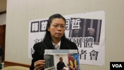 李明哲的妻子李净瑜2017年3月向媒体展示李明哲以往活动的照片 (资料照片)