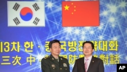 韩国国防部次官白承周(右)与中国人民解放军副总参谋长王冠中在首尔参加第三次韩中国防战略对话。(2013年11月28日)