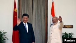 印度总理莫迪和中国国家主席习近平在新德里海德拉巴宫会晤前对媒体挥手致意。(2014年9月18日)