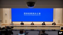 资料照片:2021年3月24日,中国学者和政府官员在北京国务院新闻办公室的新闻发布会上。(美联社照片)