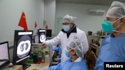 2020年2月2日,湖北省武汉市新冠病毒爆发后,医务人员在武汉大学中南医院检查一名患者的CT扫描图像。