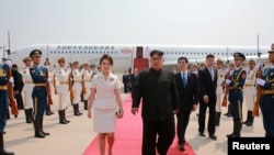 朝鲜领导人金正恩和夫人李雪主2018年6月19日抵达北京,中共中央政治局常委王沪宁迎接。