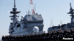 资料照:日本海上自卫队成员在横滨参加“出云级”直升机航母“加贺”号交接仪式。(2017年3月22日)