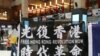 资料照:在台北车站参与支持香港行动的民众高举“光复香港时代革命”旗帜。 (2020年5月23日)