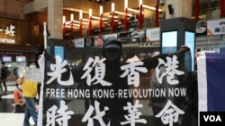 资料照:在台北车站参与支持香港行动的民众高举“光复香港时代革命”旗帜。 (2020年5月23日)