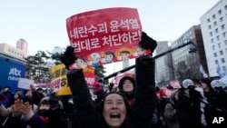 韩国首尔国会外头,集会民众听到韩国投票弹劾总统尹锡悦的消息后庆祝。(美联社:2024年12月14日)