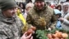 Українські військовослужбовці тримають дідухи та куштують традиційні пампушки під час Святвечора у Львові, 24 грудня 2023 року. YURIY DYACHYSHYN/AFP